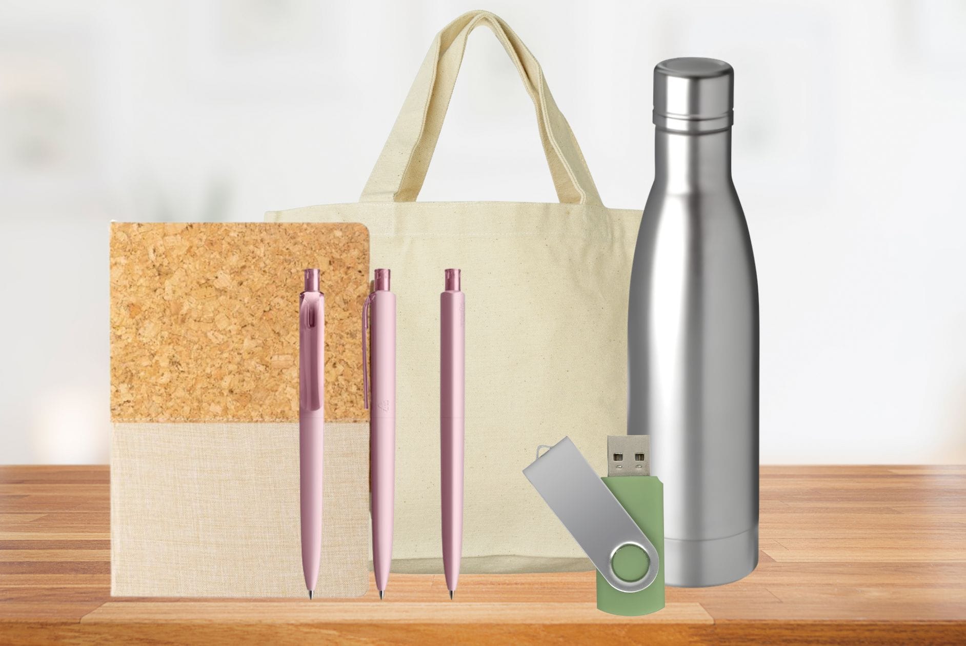 Messegeschenke, wie Kugelschreiber, Notizbuch, Flasche und USB-Stick auf einem Tisch